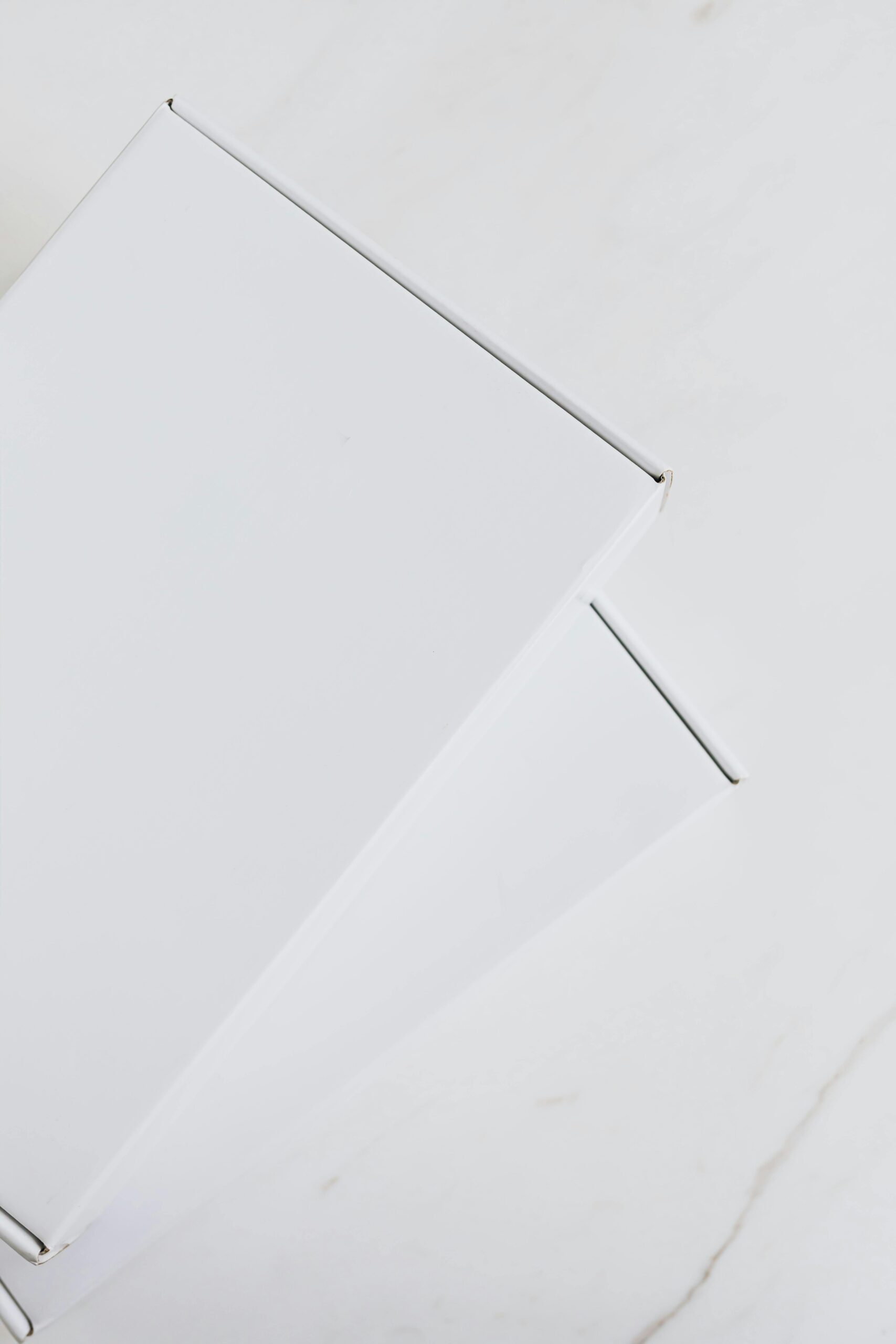 Simple white boxes on marble surface with negative space, perfect for branding.